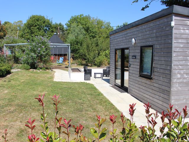 A garden with a wooden house and swing at The Hyde Clubworthy near Launceston