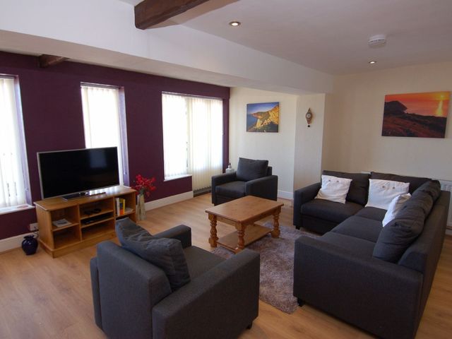 A living room with a coffee table and sofa at Old Lyn Cottage