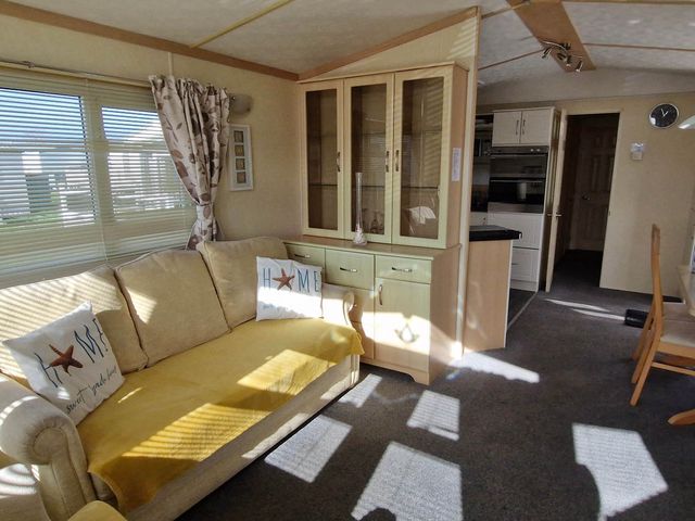 A living room with a sofa and a cabinet at Beachcomber Cabin Dog Friendly Anderby Creek Lincolnshire