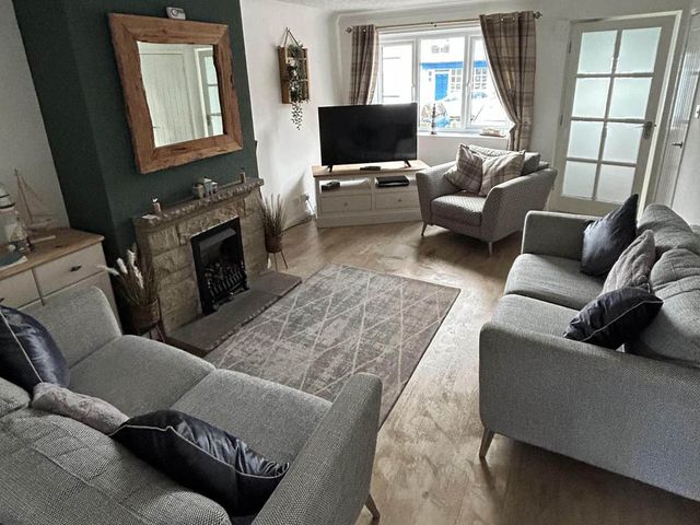 A living room with seating and a television at a property