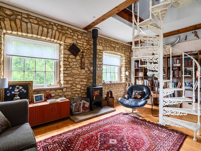 A living room with a spiral staircase and fireplace at Beautiful Pad Near World Heritage Jurassic Coast Pymore near Bridport