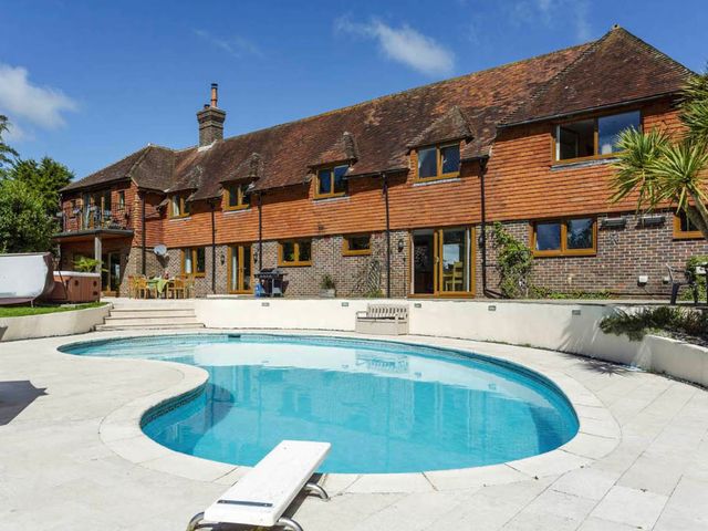 An outdoor area with a swimming pool and seating at Sleeps 10 to 18 Parking Garden Pool Hot Tub Balcony in Friston
