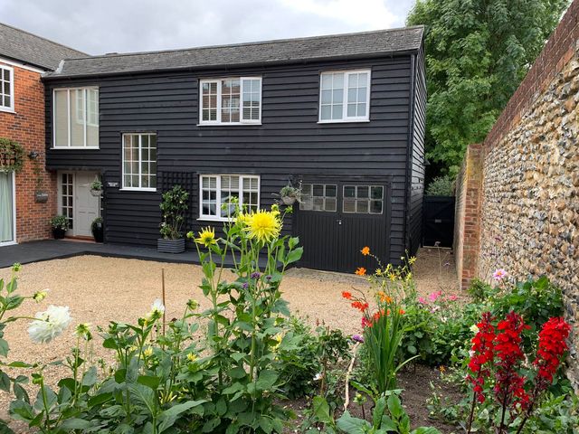 A building with a front door and windows surrounded by a flower bed at a residential property