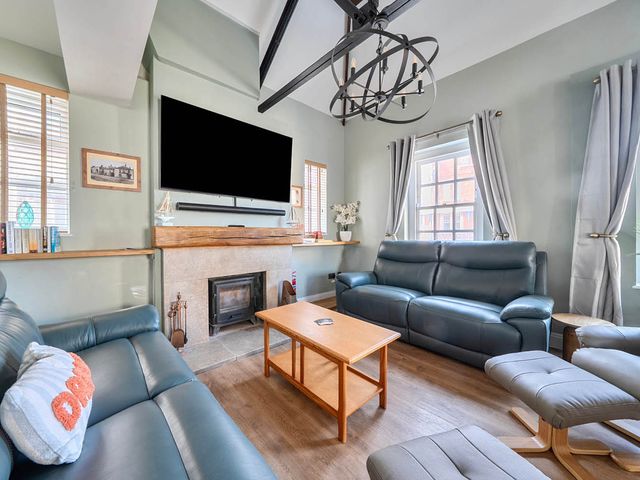 A living room with a sofa and coffee table at 4 Bed Sleeps 8 Pool Table Sea View Parking in Swanage
