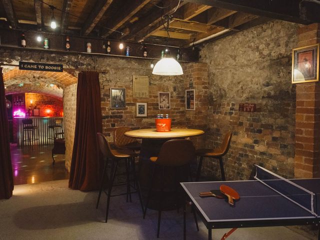 A basement with a ping pong table and seating area at 