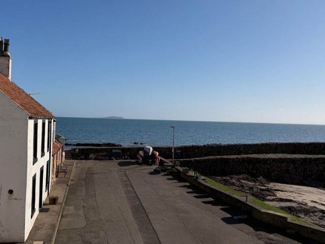 A view of the ocean and houses along a road with fishing boats at 