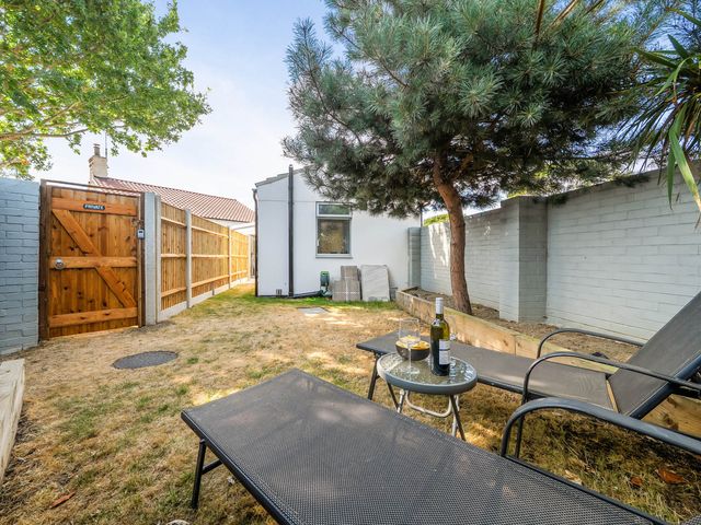 A garden with lounge chairs and a table at Annexe Bungalow Sleeps 2 Maximum Parking Garden in Scratby