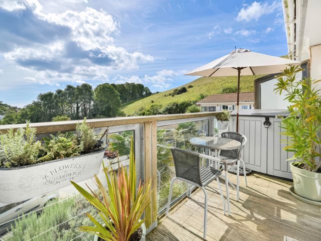 A balcony with a table and chairs at Torpoint Apartment Sleeps4 Seaside Parking, Downderry