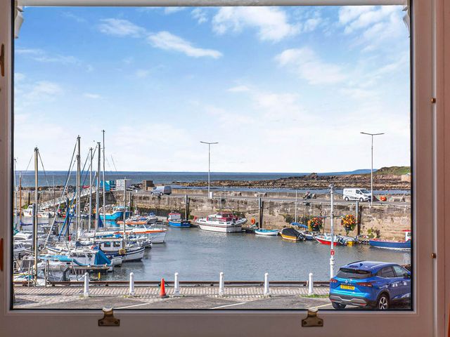 A view of a harbor with boats and vehicles at Seaview Apartment 2Bed on Anstruther Harbour Anstruther