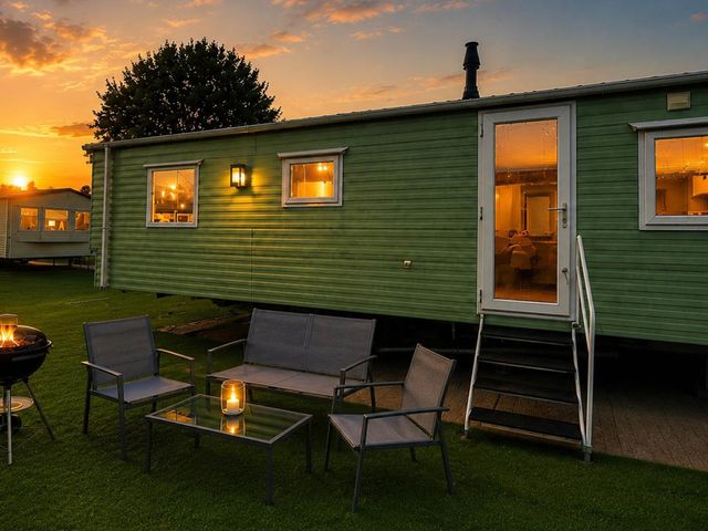 An outdoor seating area with a caravan and chairs at Billing Aquadrome Holiday Park 2bed Caravan Northampton