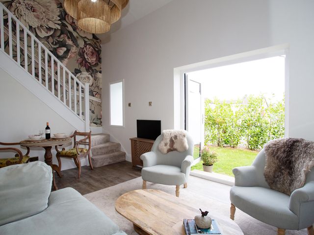 A living room with a staircase and dining area at Cozy Wetherby Retreat in Wetherby