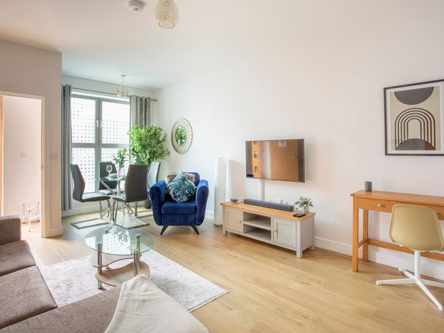 A living room with a sofa and dining area at Queens Lodge Sleeps 2 with Welcome Pack in Redhill