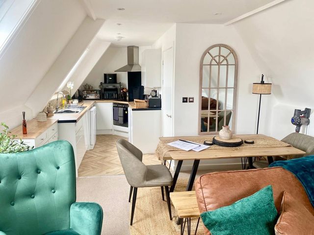 A living room with kitchen area and dining table at Central Tenby 3 Bed Apt Sleeps 6 to 8 Dog Friendly Tenby