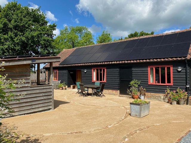 An outdoor area with a building featuring solar panels at Pet Friendly 3Bed Barn Sleeps 7 Parking Garden Westhall near Halesworth