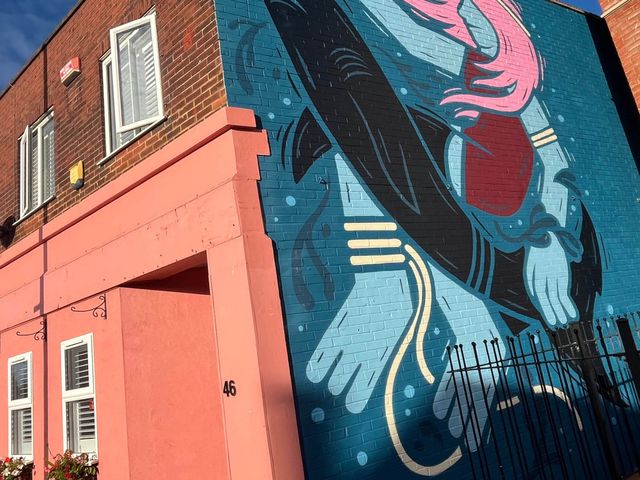 A mural on a building wall with windows and a door at 1bed apartment nr beach with garden Margate