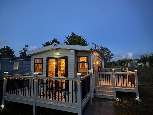 A caravan with a deck and steps at Homely Caravan in Skegness