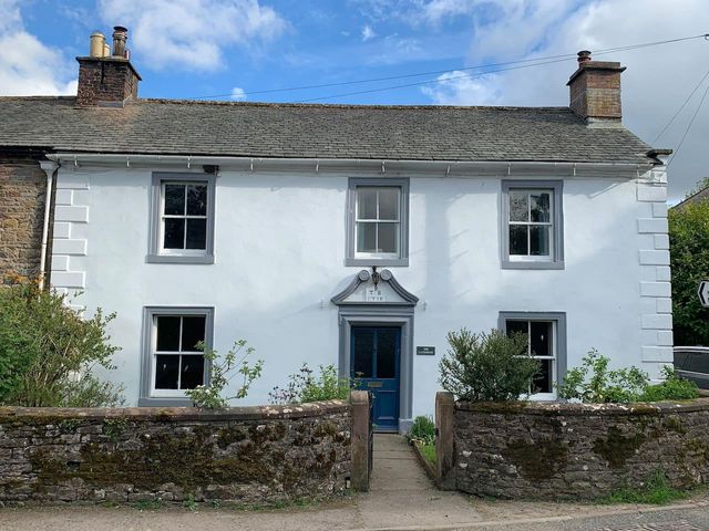 A house with a blue front door and windows at House Sleeps 10 Pet friendly Parking Caldbeck