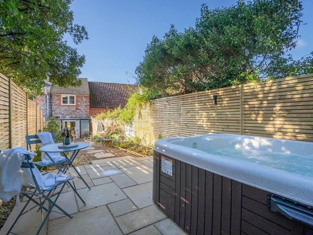 A garden with a hot tub and seating area at 1 Bed Cottage Sleeps 2 with Hot Tub Pets Welcome, Great Massingham