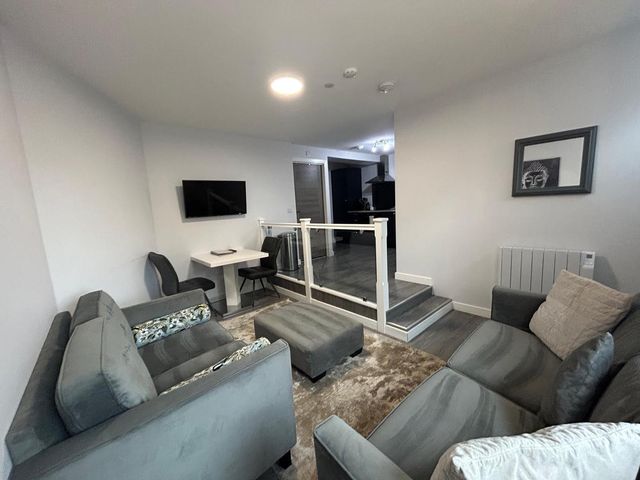 A living room with a sofa and television at Wick Harbour Apt 2 Bed Fast WiFi NC500 in Wick, Caithness