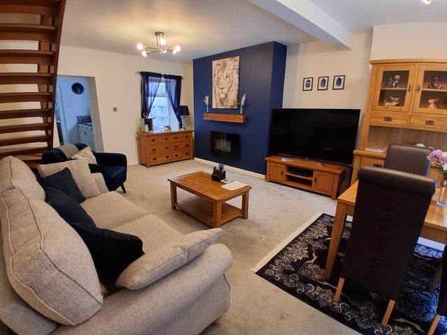 A living room with a television, sofa, and dining area at the property in Newbridge, Caerffili