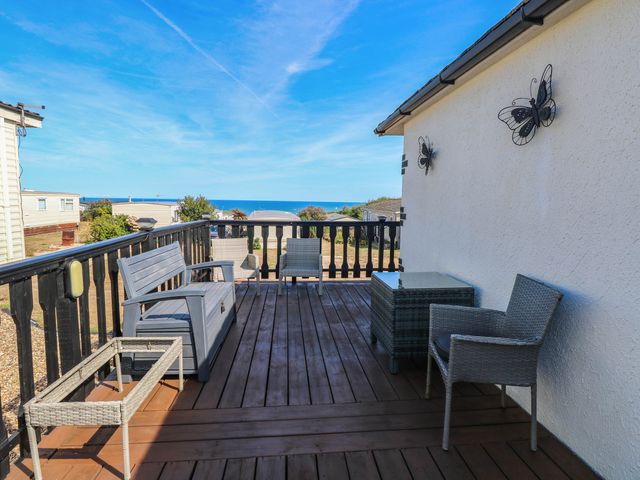 An outdoor area with furniture overlooking the sea at Sea Mist in Trimingham