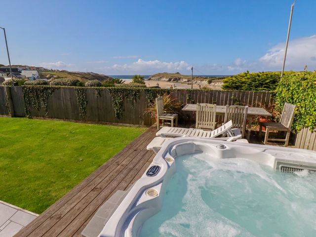 An outdoor area with a hot tub and seating at Mermaid Gaze in Newquay