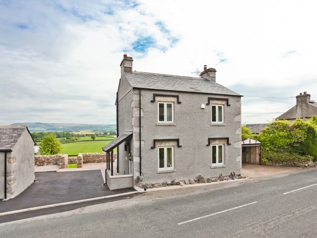 A house with windows and a driveway at Hillberry Cottage in Carnforth