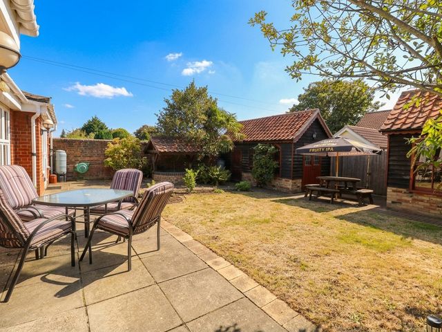 A garden with a table and chairs at The Mill House Apartment