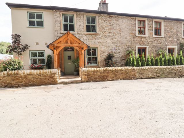 A house with stone wall and wooden door at Cottage by the River in Burnley