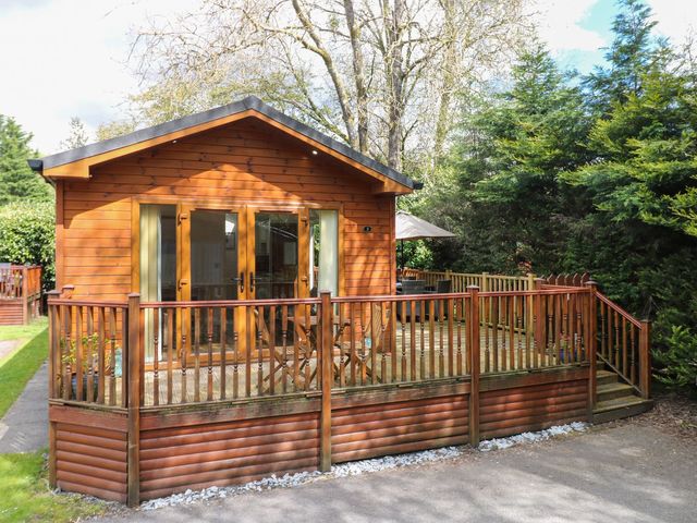 A wooden lodge with a deck at Fir Tree Lodge, Coniston 3, White Cross Bay near Windermere