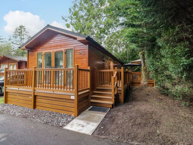 A lodge with a deck and steps at Fir Tree Lodge, White Cross bay on Windermere, Troutbeck Bridge