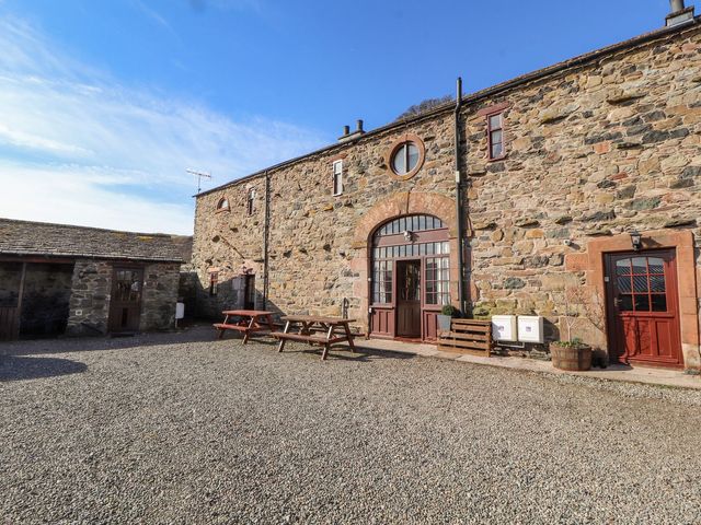 An outdoor area with stone walls and seating at Mellfell Cottage near Watermillock