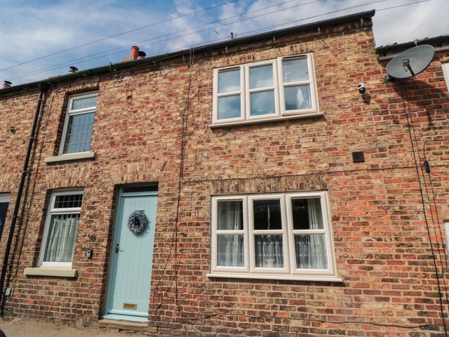 A brick exterior with a front door and windows at 45 St. Hildas Street in Sherburn