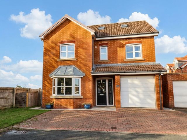 A house with a garage and windows at 64 Derwent Road in Whitby