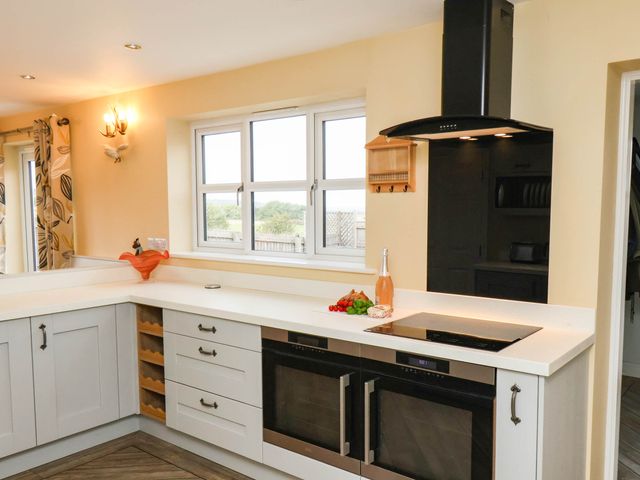 A kitchen with appliances and a window at 64 Derwent Road Whitby