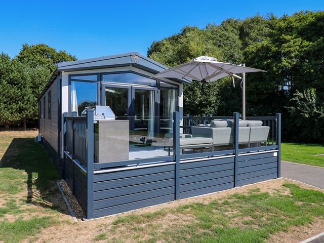A mobile home with a decking area and sofa at Lakewood Plot 9 St. Osyth