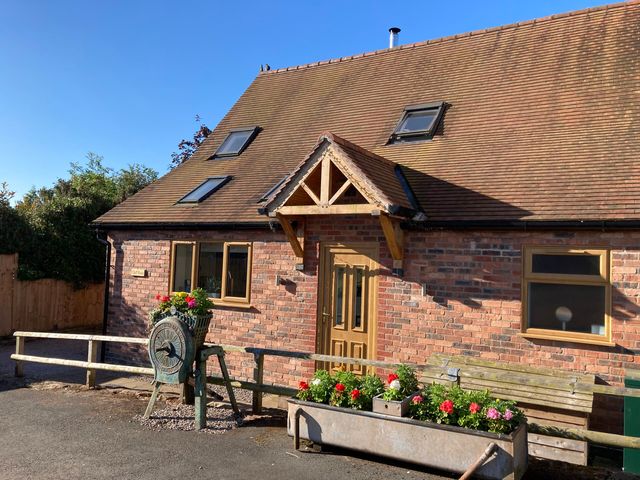 A house with a wooden door and flower planter at Chaff House Worcester
