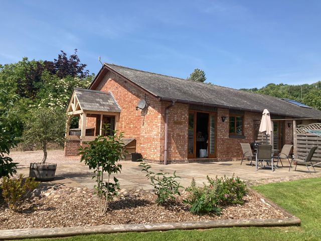 A brick house with patio furniture and garden plants at Bramley in Worcester