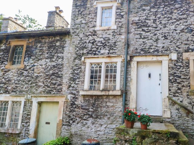 An exterior view of a stone cottage with a door and windows at 73 Ravensdale Cottages Cressbrook near Litton, Derbyshire