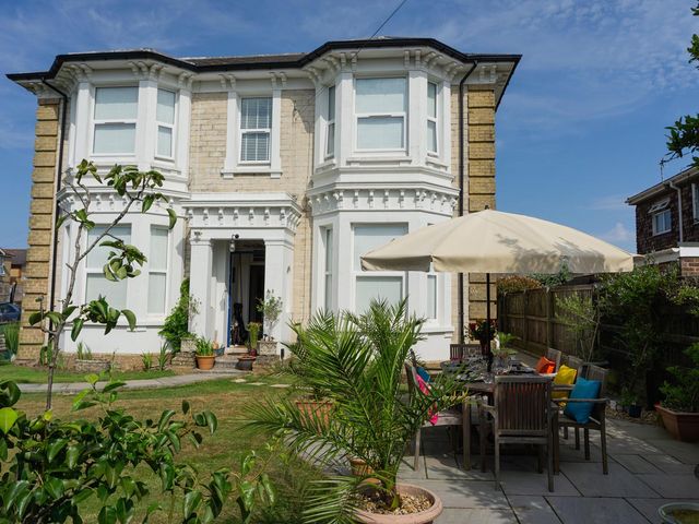 A house with an outdoor seating area and plants at Lovely, spacious apartment - sleeps 5 in Ryde