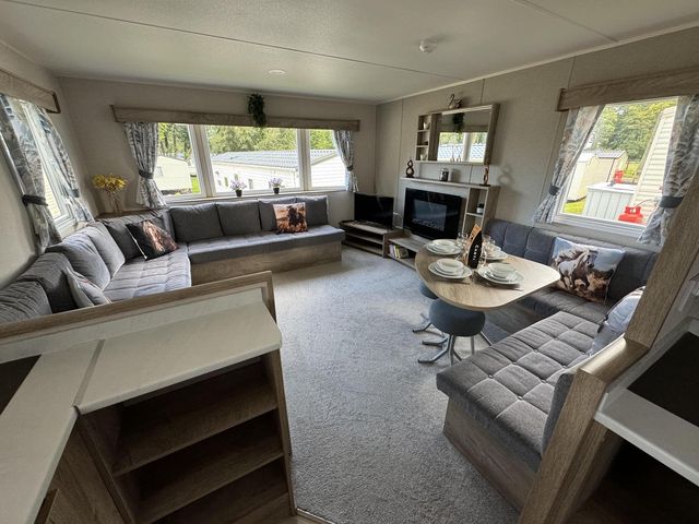 A living room with a sofa, coffee table, and television at West Lawn 47 Haggerston Castle Paddock Views, Haggerston