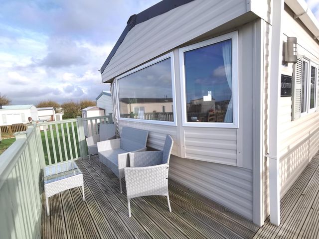 An outdoor seating area with chairs and a table at Snowdonia Sunbeach Holiday Sea and Mountain view, Llwyngwril