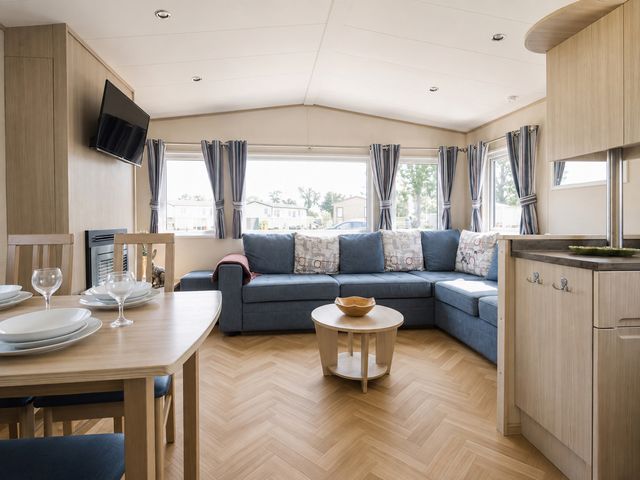 A living room with a sofa and dining area at Caravan - Sleeps 8 - Parking Northampton
