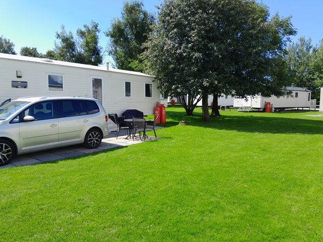 An outdoor area with a car parked next to a mobile home at Ye Old'e Man - Sleeps 6 & Pet Friendly Near Flookburgh