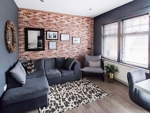 A living room with a sofa and a table at Modern Apartment - Sleeps 4 - Centrally located, Lanark