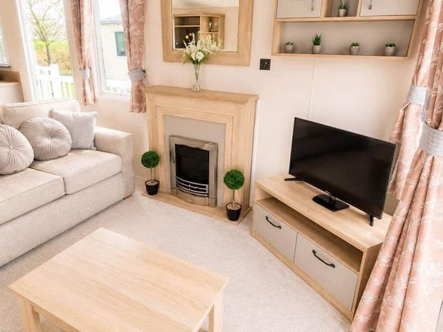 A living room with a sofa and television at Tattershall Lakes - Hot Tub - Sleeps 6 - Pets in Tattershall
