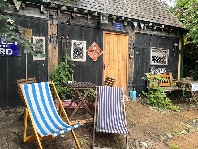 An outdoor area with deck chairs and wooden furniture at the property in Bovey Tracey