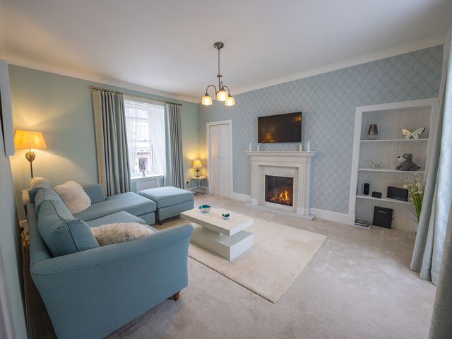 A living room with a sofa and coffee table at Short Walk to the Beach - 2 Guests - Free Parking Thurso