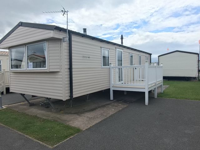 A caravan with a deck and antenna at Golden Sands 3-Bed Caravan, Parking and Pet Friendly in Towyn