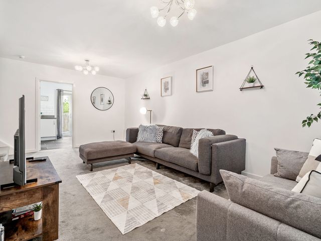 A living room with a sofa and television at House, sleeping 4 with Garden and Parking Ashford